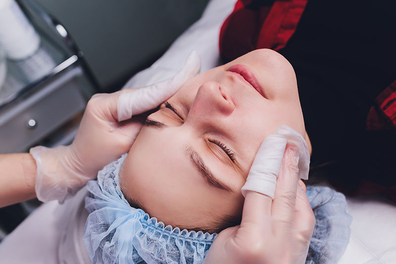 woman getting face cleaned